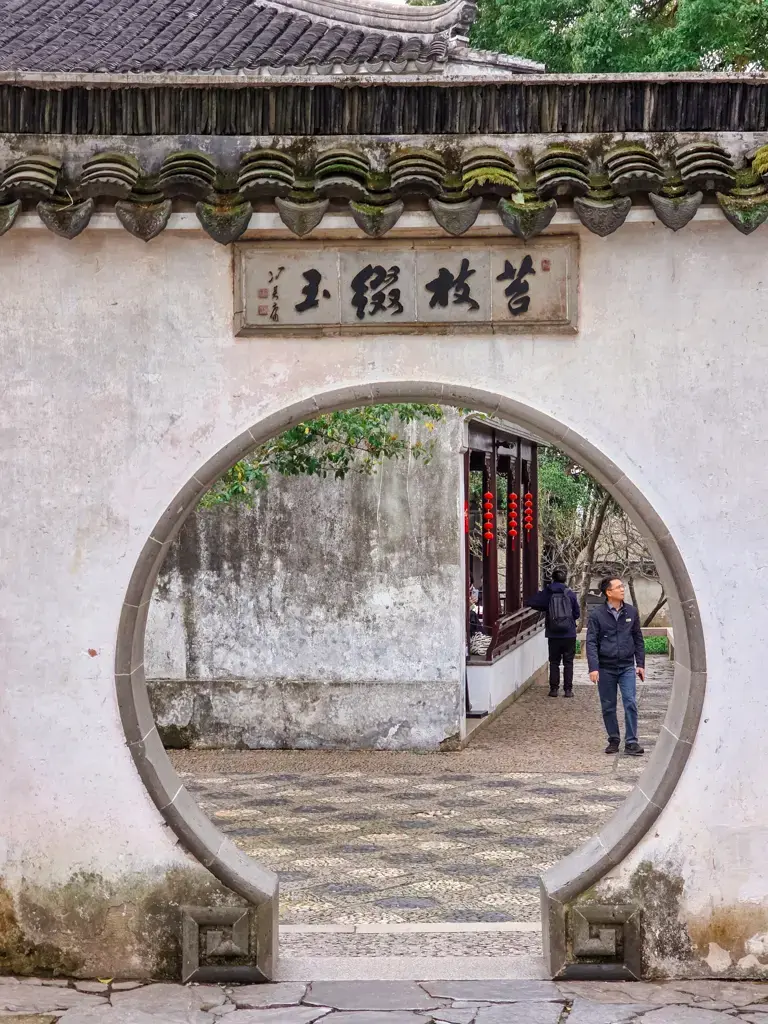 2026 蘇州旅遊攻略|5日遊深度自由行:避開人潮的園林路線、美食、住宿、交通一次搞懂 蘇州虎丘劍池月洞門入口,虎丘三槐堂古匾額白牆紅燈籠,蘇州古典園林門戶圓拱景框石板路綠蔭,吳中第一名勝吳王墓傳奇景點