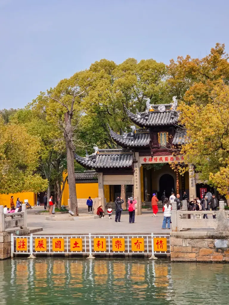 2026 蘇州旅遊攻略|5日遊深度自由行:避開人潮的園林路線、美食、住宿、交通一次搞懂 蘇州西園寺入口景致,臨水照壁與「情有樂利土國嚴莊」牌示,蘇州旅遊必去寺廟
