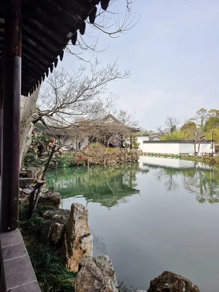 2026 蘇州旅遊攻略|5日遊深度自由行:避開人潮的園林路線、美食、住宿、交通一次搞懂 蘇州景點滄浪亭的古典園林水景:岸邊迴廊與白牆建築倒映於平靜水面,呈現江南水鄉特有的幽靜旅遊氛圍。