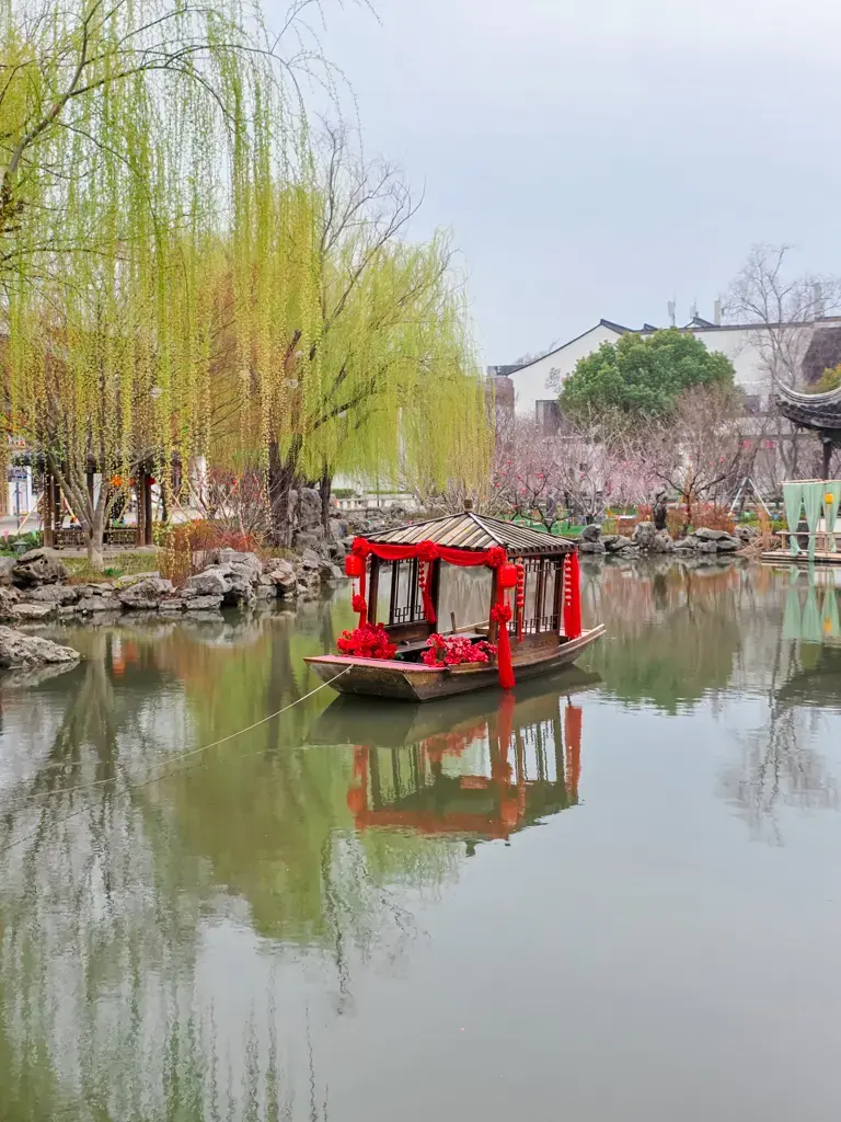 2026 蘇州旅遊攻略|5日遊深度自由行:避開人潮的園林路線、美食、住宿、交通一次搞懂 蘇州旅遊美景:唐寅故居入口西池,池中停泊著精緻紅花畫舫,岸邊楊柳依依,是蘇州自由行旅客體驗蘇州園林詩情畫意的絕佳景點。