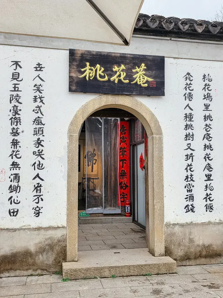 2026 蘇州旅遊攻略|5日遊深度自由行:避開人潮的園林路線、美食、住宿、交通一次搞懂 蘇州旅遊打卡景點:唐寅故居桃花庵入口,牆面書寫經典詩句桃花庵歌,是蘇州自由行探索人文歷史與蘇州園林美學的熱門拍照位。