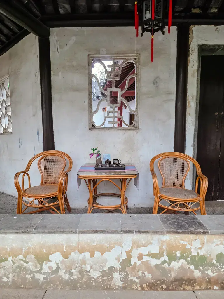 2026 蘇州旅遊攻略|5日遊深度自由行:避開人潮的園林路線、美食、住宿、交通一次搞懂 蘇州虎丘「雲在茶香」茶室角落,中式藤椅茶座與傳統蘇州園林漏窗景觀