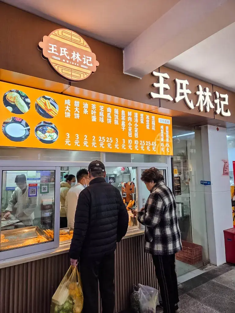 2026 蘇州旅遊攻略|5日遊深度自由行:避開人潮的園林路線、美食、住宿、交通一次搞懂 蘇州月泊灣壹號菜市場,王氏林記燒餅油條攤位,清晨本地人排隊購買的熱鬧早餐畫面