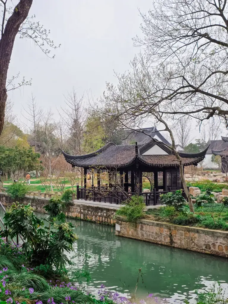 2026 蘇州旅遊攻略|5日遊深度自由行:避開人潮的園林路線、美食、住宿、交通一次搞懂 蘇州虎丘風景區內的傳統江南園林建築,緊鄰河道的黑瓦木造涼亭與清澈水景。
