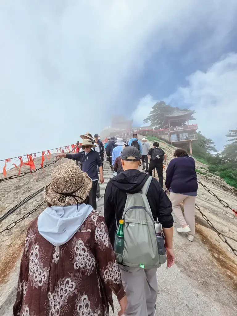 西安華山步道上絡繹不絕的登山人潮,兩側是險峻的鐵鍊與絕壁