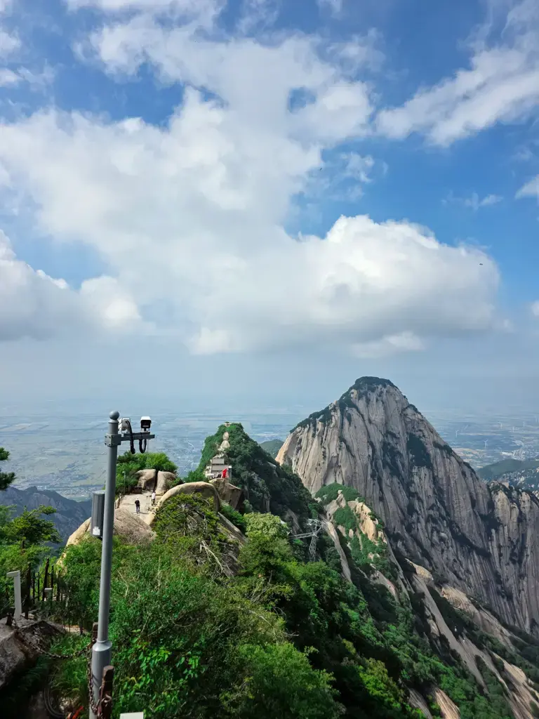 遊客在陝西華山險峻山脊步道攀爬,遠眺中國華山奇峰與壯麗峽谷景觀