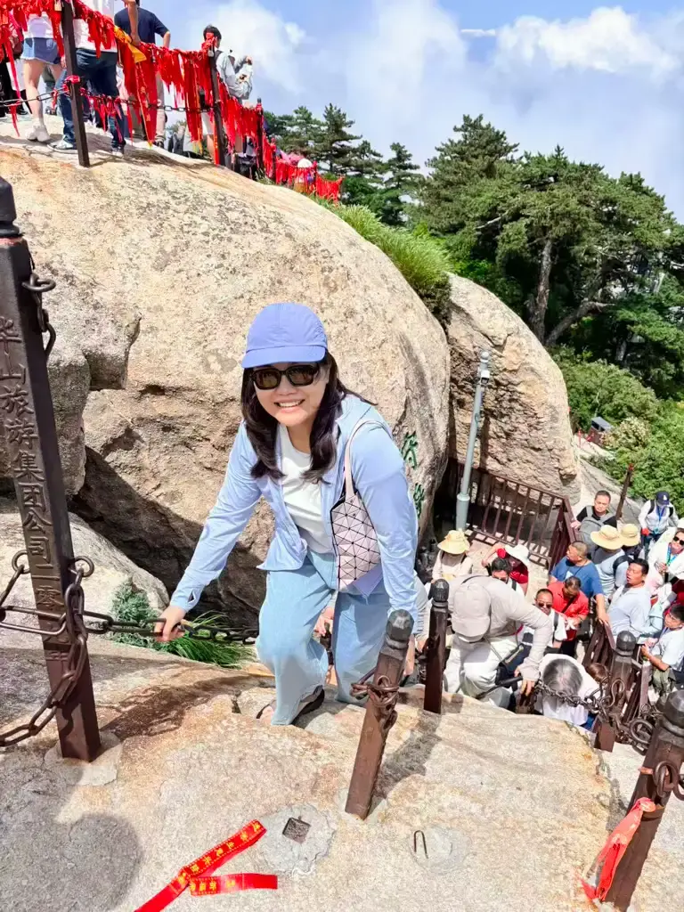 遊客在西安華山險峻的石階上挑戰攀爬,展現爬華山的活力與熱情