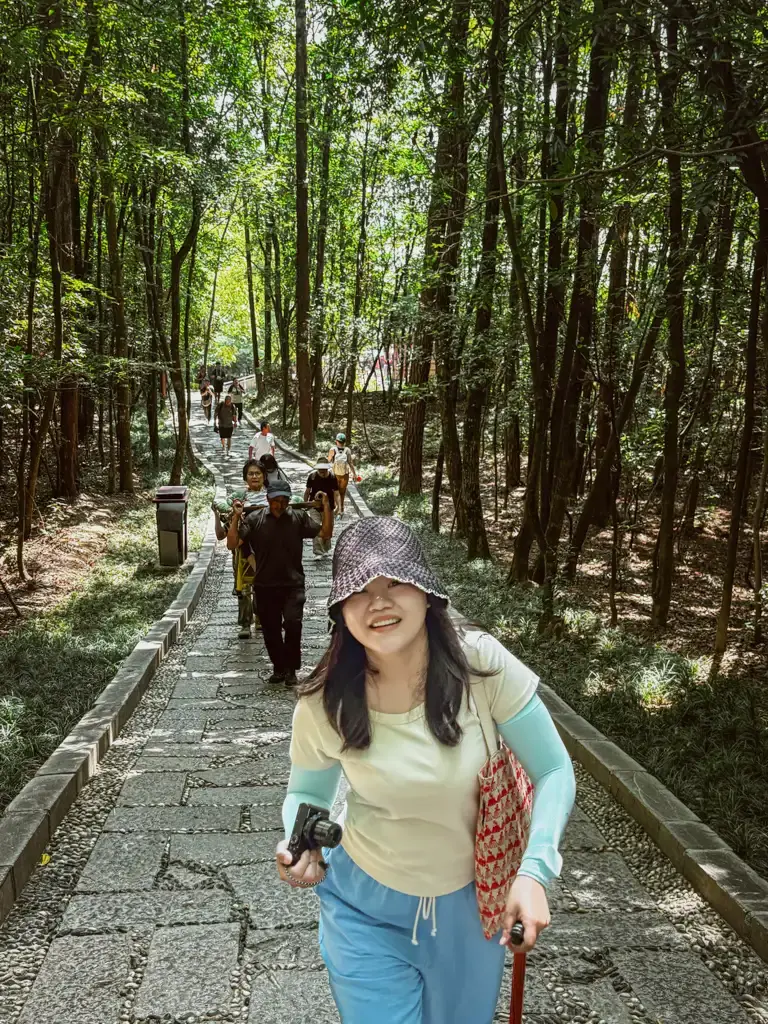 作者於前方步道行走,後方轎夫抬著媽媽行經楊家界林蔭步道
