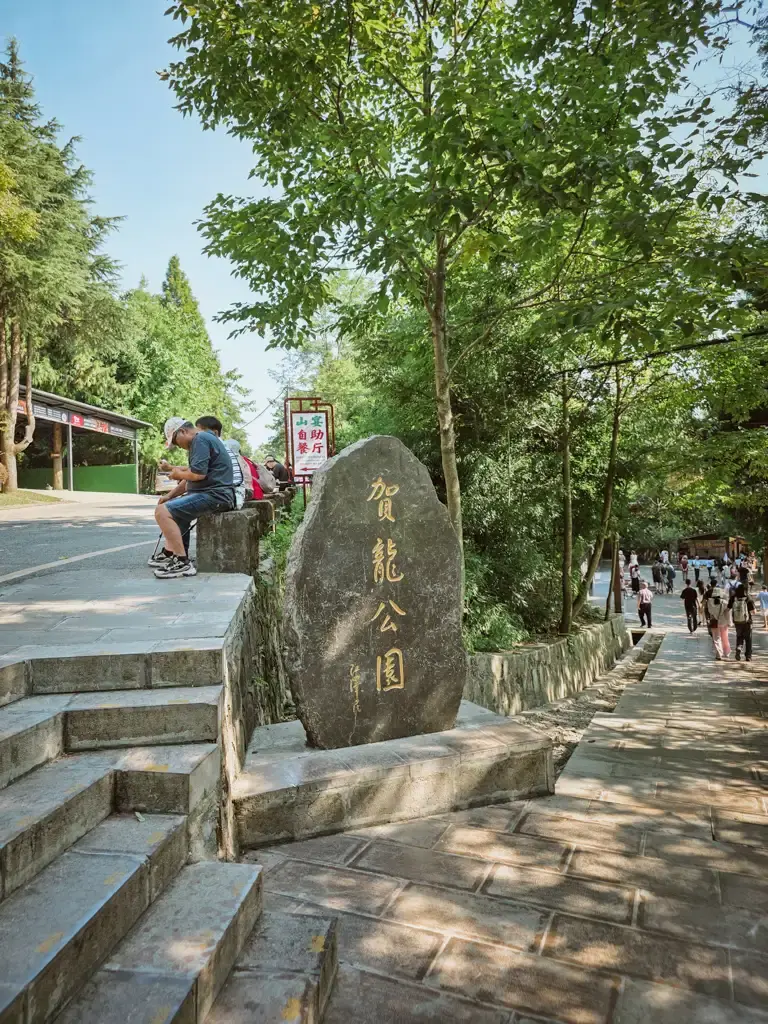 張家界天子山賀龍公園入口石碑,周圍綠樹環繞,兩側設有階梯與遊客步道